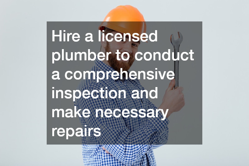 plumber holding a wrench and wearing a hard hat